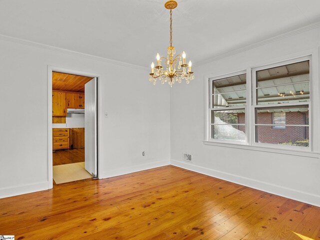 unfurnished room featuring crown molding, a chandelier, and hardwood / wood-style flooring