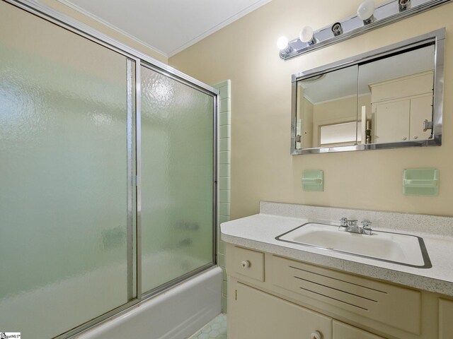 bathroom with vanity, bath / shower combo with glass door, and crown molding