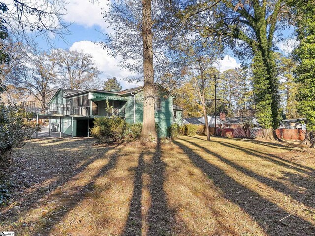 view of yard with a deck and a sunroom