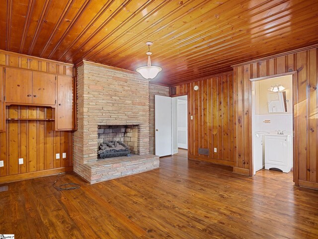 unfurnished living room with hardwood / wood-style floors, wooden walls, and wooden ceiling