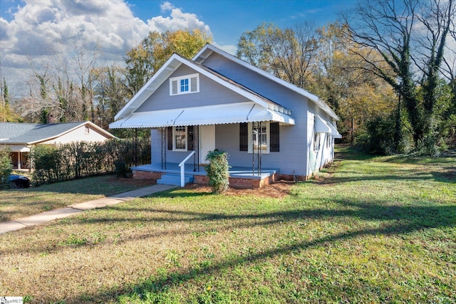 bungalow featuring covered porch and a front yard