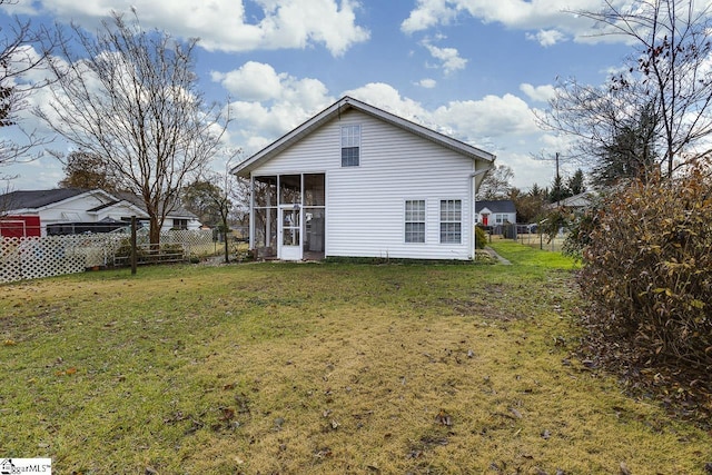 back of property with a yard and a sunroom