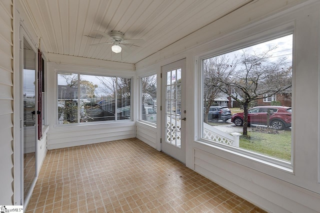 unfurnished sunroom featuring plenty of natural light, ceiling fan, and wooden ceiling