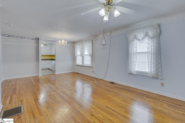 unfurnished room with light hardwood / wood-style flooring and ceiling fan with notable chandelier