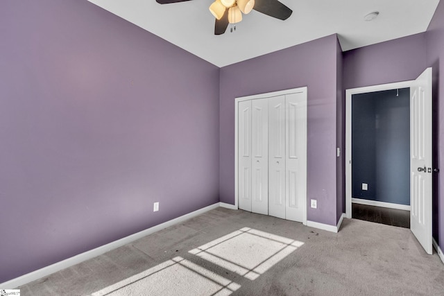 unfurnished bedroom with ceiling fan, a closet, and light carpet