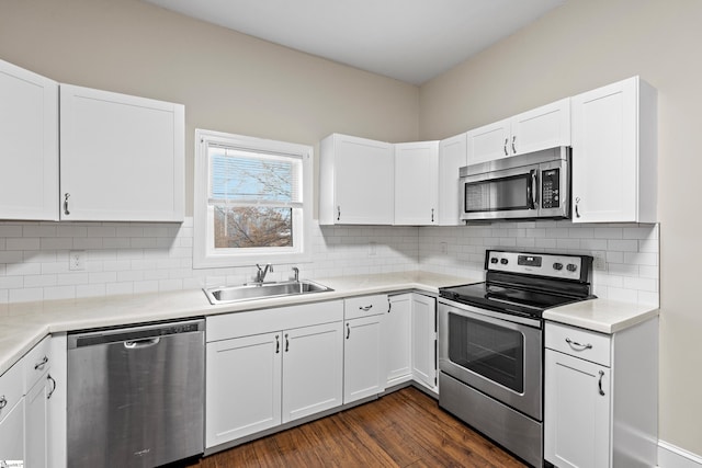 kitchen with backsplash, white cabinets, sink, dark hardwood / wood-style flooring, and stainless steel appliances