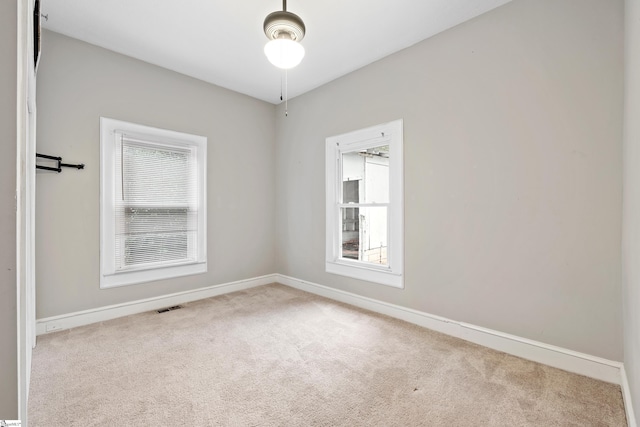 unfurnished room featuring light colored carpet