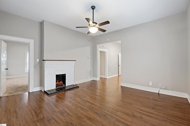 unfurnished living room featuring ceiling fan, dark hardwood / wood-style flooring, and a fireplace
