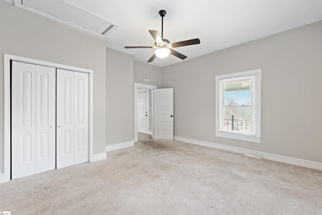 unfurnished bedroom with ceiling fan, a closet, and light colored carpet