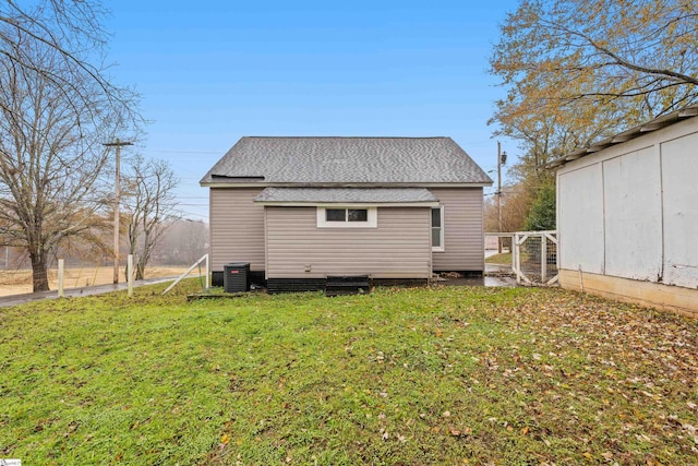 back of house with central AC and a yard
