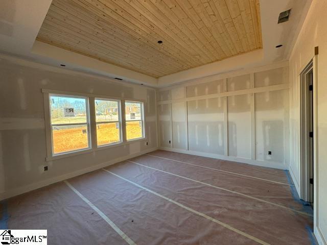 unfurnished sunroom with wood ceiling and a raised ceiling