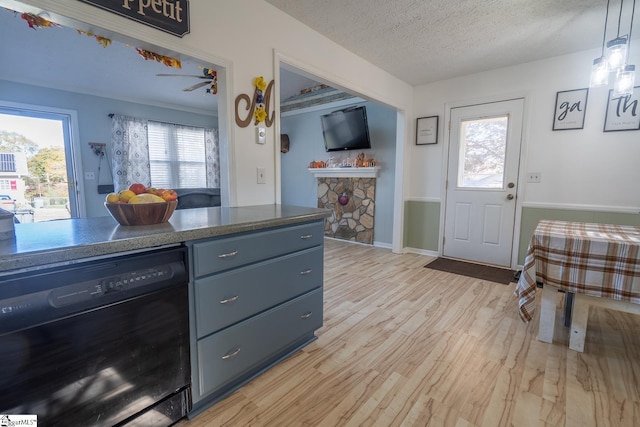 kitchen featuring ceiling fan, a textured ceiling, black dishwasher, decorative light fixtures, and light hardwood / wood-style floors