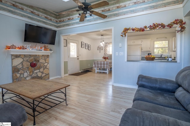 living room with light hardwood / wood-style flooring, ceiling fan, and a baseboard heating unit