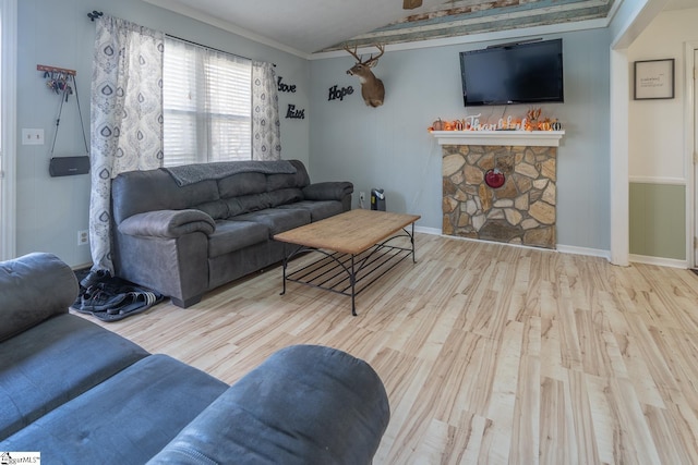 living room featuring lofted ceiling, light wood-type flooring, and crown molding