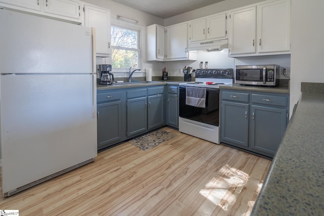 kitchen featuring white appliances, sink, light wood-type flooring, a textured ceiling, and white cabinetry