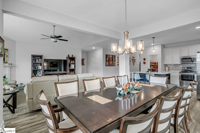 dining room featuring ceiling fan with notable chandelier, light hardwood / wood-style floors, and beam ceiling