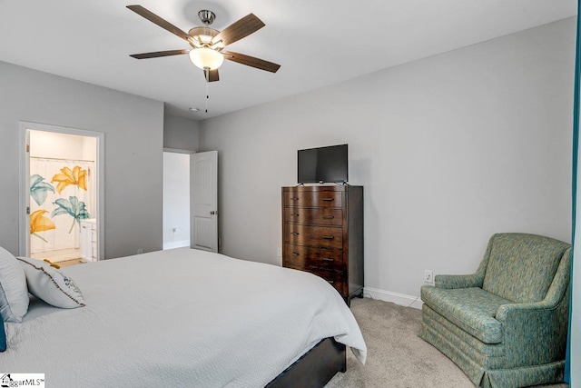 carpeted bedroom with ensuite bath and ceiling fan