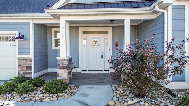 doorway to property featuring covered porch and a garage