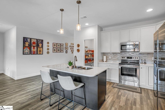 kitchen featuring white cabinetry, sink, an island with sink, and appliances with stainless steel finishes