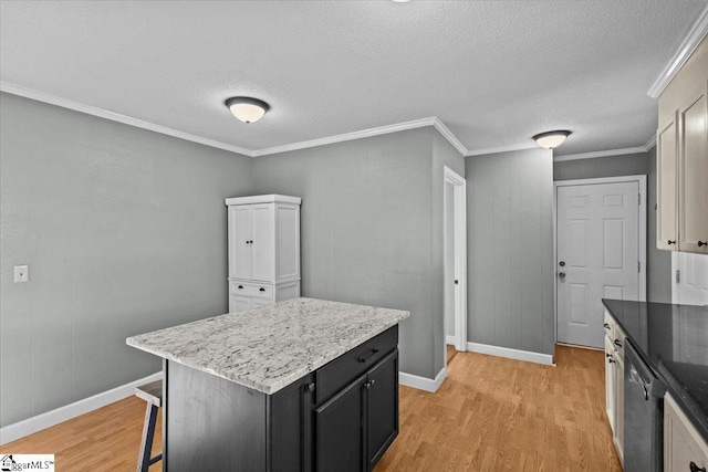 kitchen with a center island, stainless steel dishwasher, light wood-type flooring, ornamental molding, and a textured ceiling