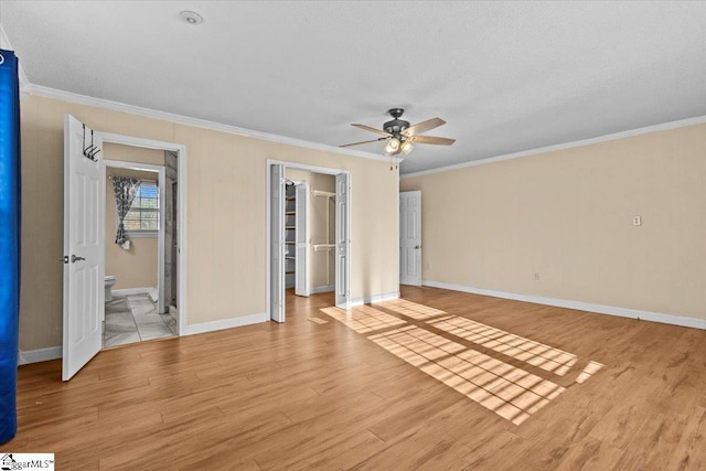 unfurnished bedroom featuring ornamental molding, ceiling fan, light hardwood / wood-style flooring, connected bathroom, and a closet