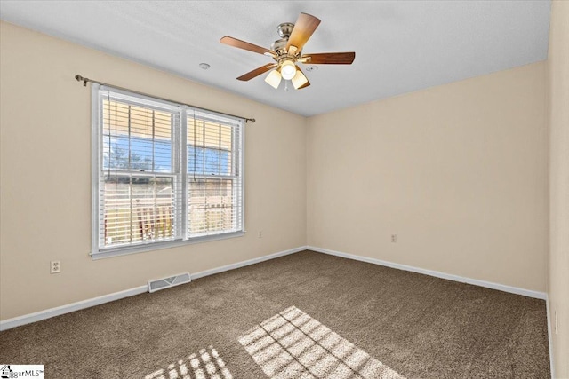 carpeted empty room with ceiling fan and plenty of natural light