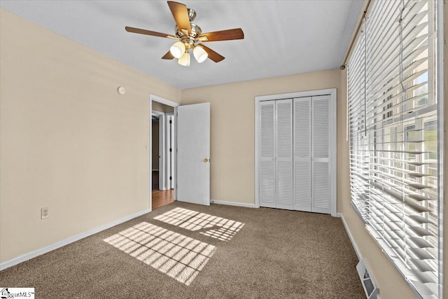 unfurnished bedroom with ceiling fan, a closet, and carpet