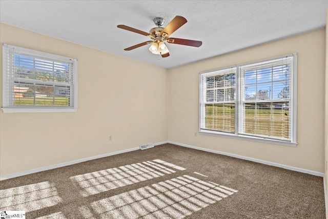 carpeted empty room featuring ceiling fan and a textured ceiling