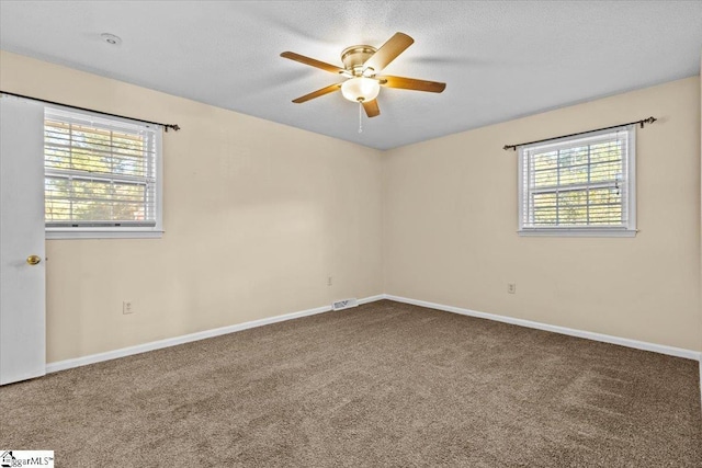 unfurnished room with ceiling fan, carpet, and a textured ceiling