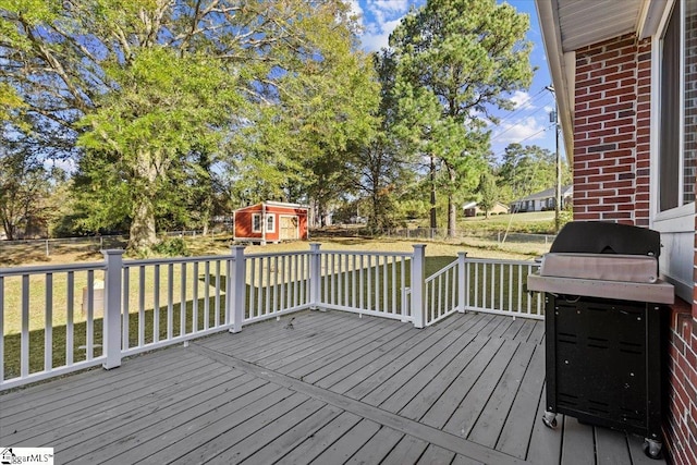 wooden deck with area for grilling and a storage shed