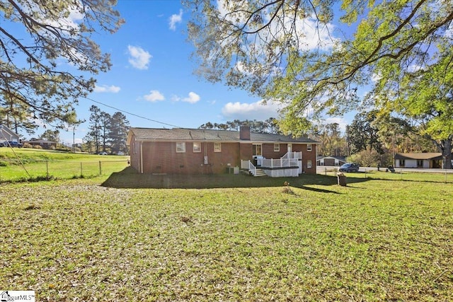 rear view of house with a yard and cooling unit