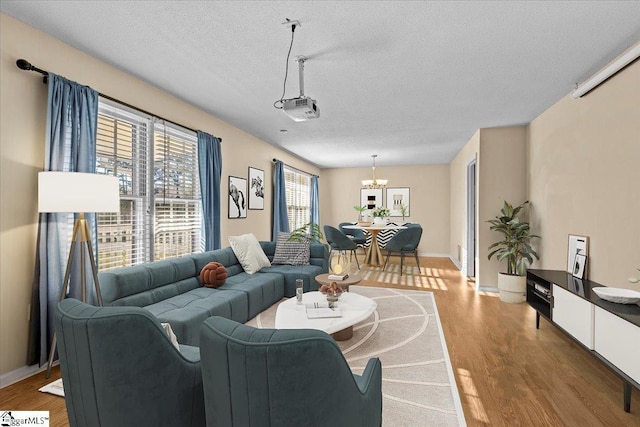 living room featuring a notable chandelier, a textured ceiling, and hardwood / wood-style flooring