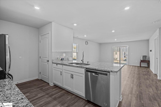 kitchen featuring light stone counters, stainless steel appliances, white cabinetry, and sink