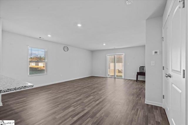 interior space with a wealth of natural light and dark hardwood / wood-style flooring