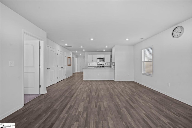 unfurnished living room featuring dark hardwood / wood-style floors and sink