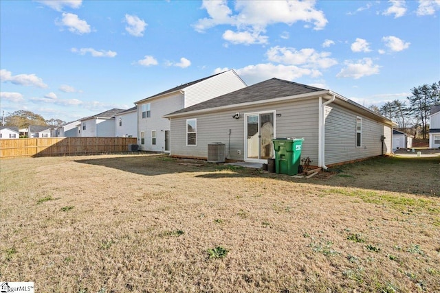 back of house with a lawn and central AC unit