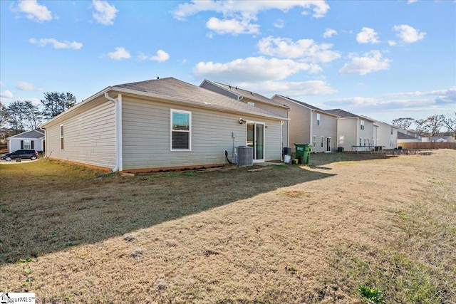 back of house featuring cooling unit and a lawn