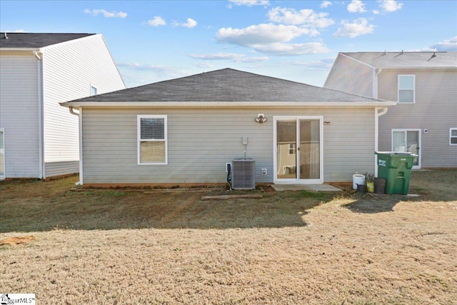 rear view of house featuring a yard and central AC unit