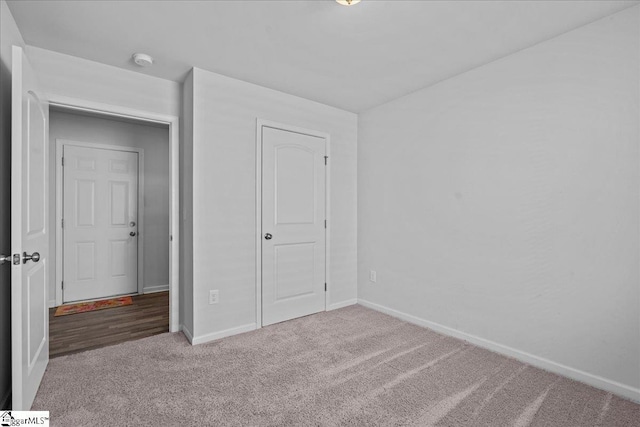 unfurnished bedroom featuring carpet flooring and a closet