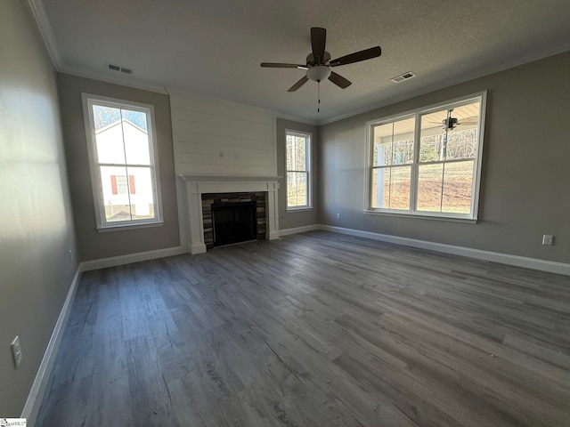 unfurnished living room with ceiling fan, crown molding, wood-type flooring, and a textured ceiling