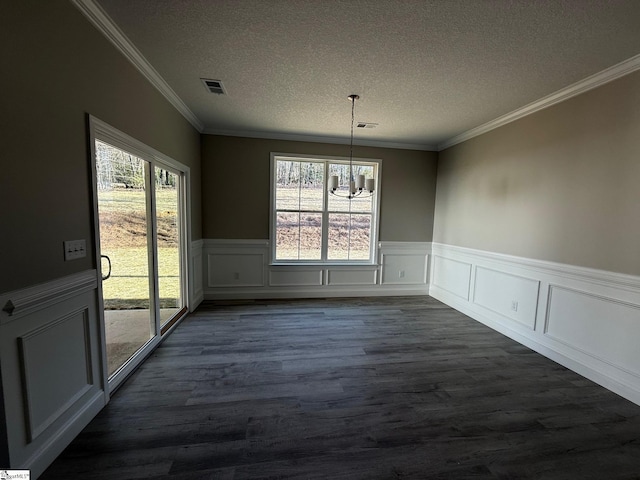 unfurnished dining area featuring ornamental molding, dark wood-type flooring, a textured ceiling, and an inviting chandelier