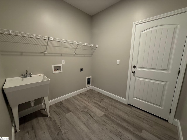 washroom with hookup for an electric dryer, light hardwood / wood-style floors, and hookup for a washing machine