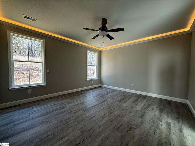 spare room with dark wood-type flooring, ceiling fan, and a tray ceiling