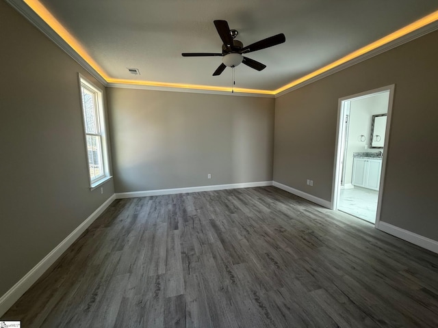 spare room featuring dark wood-type flooring, ceiling fan, and ornamental molding