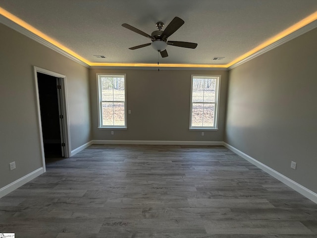 empty room with crown molding, plenty of natural light, dark hardwood / wood-style floors, and ceiling fan