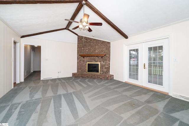 unfurnished living room with dark colored carpet, lofted ceiling with beams, crown molding, a brick fireplace, and ceiling fan