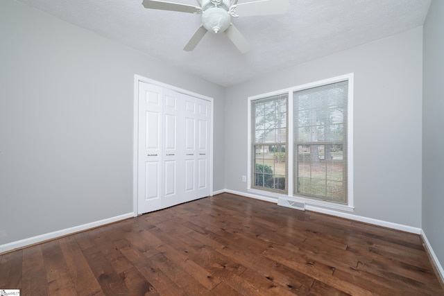 unfurnished bedroom with a closet, ceiling fan, hardwood / wood-style floors, and a textured ceiling