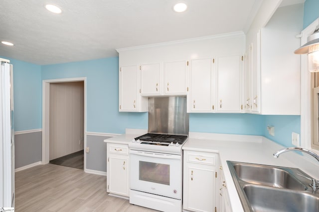 kitchen with crown molding, sink, light hardwood / wood-style floors, white range oven, and white cabinetry