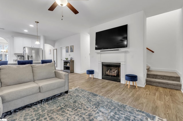 living room with ceiling fan and light wood-type flooring