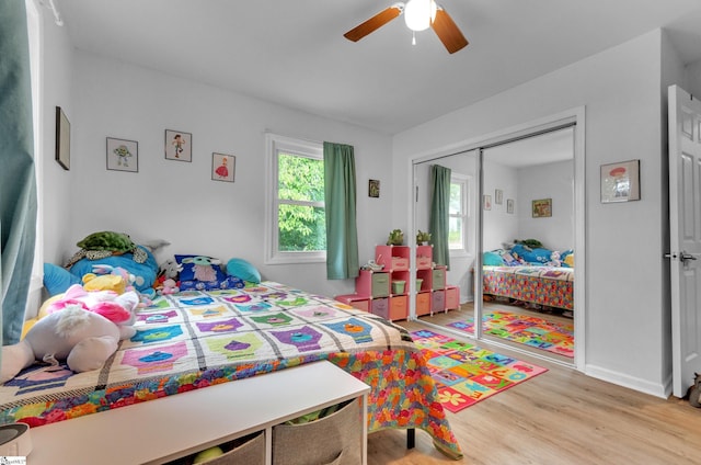 bedroom featuring ceiling fan, a closet, and light hardwood / wood-style floors